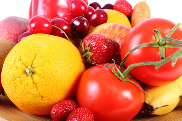Obraz na płótnie Canvas Fresh fruits and vegetables on wooden plate