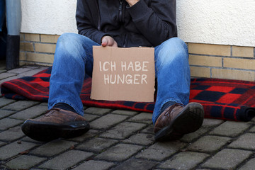 Schild "Ich habe Hunger" von Bettler gehalten