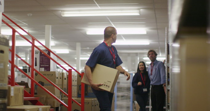 Workers in a warehouse or factory checking stock and preparing deliveries