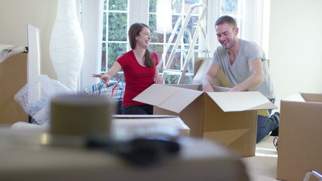  Happy young couple unpacking boxes, moving into new home