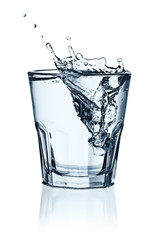 Ice cubes splashing into glass of water