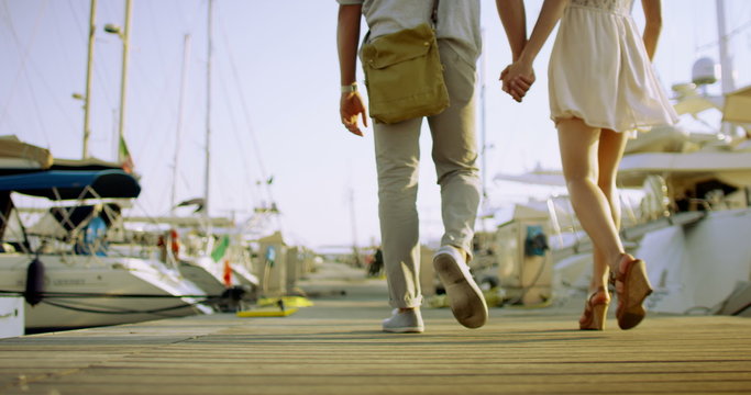 Attractive romantic couple in summertime looking at the boats in the harbor