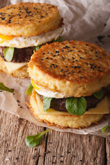 New fast food: ramen burger close-up on the wooden table. Vertical
