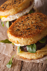 Two ramen burgers with egg and cheese close-up. vertical
