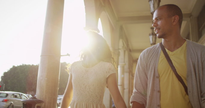  Happy attractive couple walking in the city in summertime. 