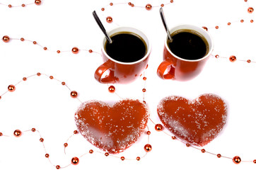 Two red cups of coffee and two hearts on a white background.
