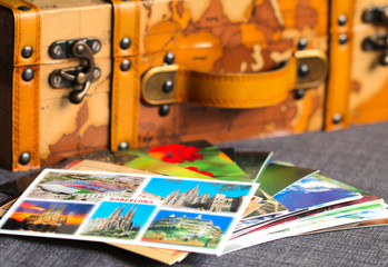 Colorful postcards of an old vintage leather suitcase on the background