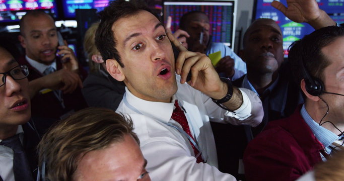  Diverse group of stockmarket traders frantically buying and selling on the trading floor. Shot on RED Epic.