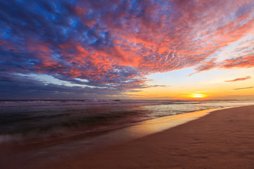 Fototapeta na wymiar Beautiful colored clouds at the beach at sunset