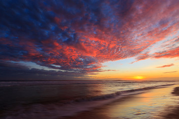 Beautiful colored clouds at the beach at sunset