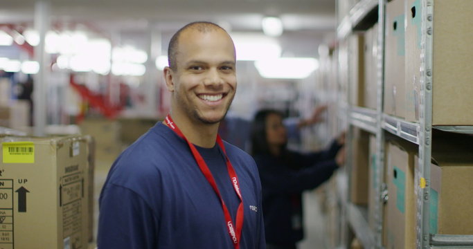 Portrait of cheerful male worker in a warehouse or factory