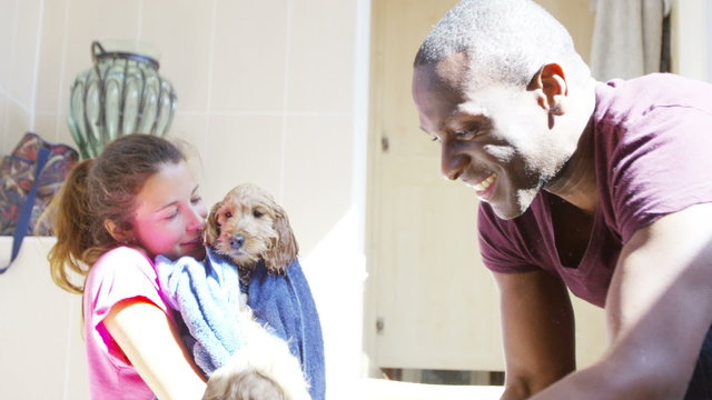 Cute puppies bath time - couple at home giving their pets a bath. 
