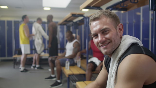  Portrait of smiling man in gym locker room or sports team changing room