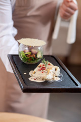Professional male waiter is serving a customer