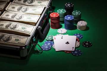 Money, cards and poker chips in the suitcase 