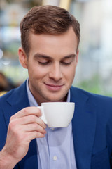 Attractive businessman is enjoying coffee at restaurant