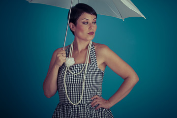 Fototapeta premium girl vintage 50s dress with white umbrella over blue background