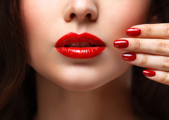 Naklejka premium Red Sexy Lips and Nails closeup. Open Mouth. Manicure and Makeup. Make up concept. Half of Beauty model girl's face isolated on black background
