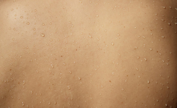 Close up view of a woman's rear  with drops of water running down her wet skin