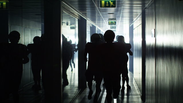  Excited American football team celebrate a victory as they run through tunnel