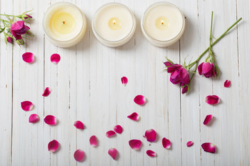 roses with candles on a wooden background