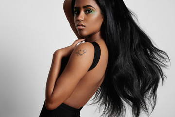 Fototapeta premium piękna czarna kobieta z boku z dmuchającymi włosami