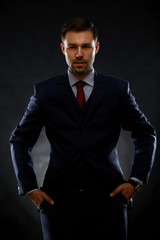 Obraz premium Handsome young business man standing on black background