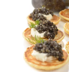 Foto op Plexiglas Mini pancakes with black caviar © olyina