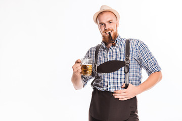Happy smiling man with leather trousers (lederhose) holds oktoberfest beer glass. Isolated on white background