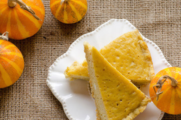 Cake on a plate and pumpkins on the burlap