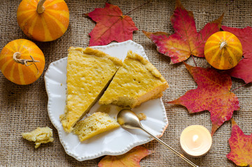 The pieces of pie on a plate, pumpkins and autumn leaves