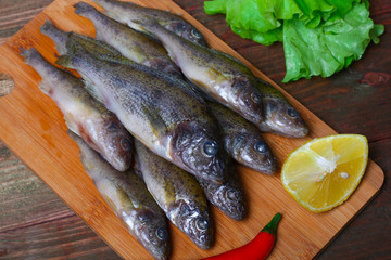 raw redfish ruff fish on the kitchen table with vegetables and lemon