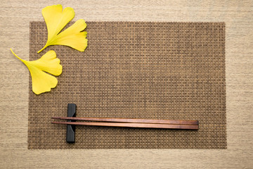 chopsticks and fallen leaves on the place mat