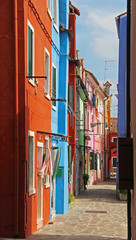 Fototapeta na wymiar Narrow street with colorful apartment houses in Burano, Venice, Italy