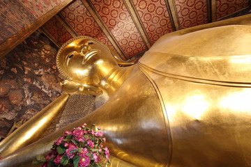 reclining buddha gold statue face at wat pho in bangkok