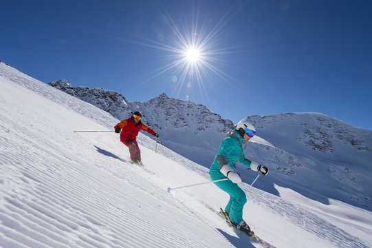  ski downhill with sun in the background