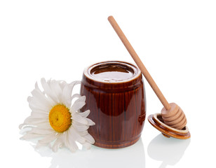 Honey on wooden dipper and jar
