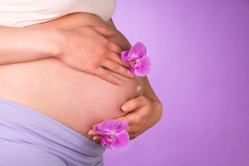 Pregnant belly with orchid flowers