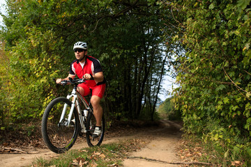 Fototapeta na wymiar Biker on the forest road riding outdoor