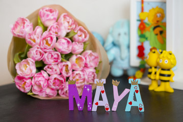 Букет розовых тюльпанов в бумажной обертке и буквы 