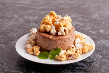 Chocolate mini-cake with caramel and popcorn, decorated mint