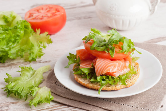 sandwich with smoked salmon and vegetables, close-up, vertical