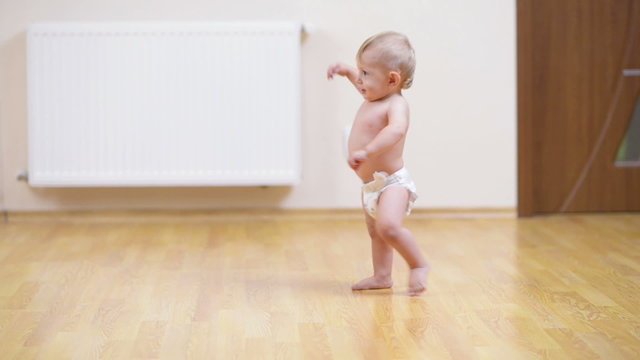 Baby making his first steps on the floor at home