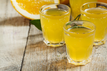 Orange soda on a background of fresh oranges on old wooden table