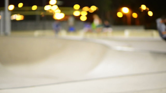 People spending the night in the summer skate park, blurred for backgrounds