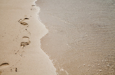 Footprints in the sand; tranquil and peaceful vacation memory
