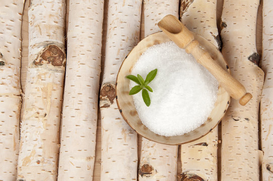  birch sugar and leaves of stevia on bitch background