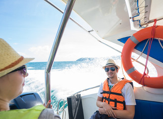 Couple wearing in  life jacket  and smiling   on  speed boat 