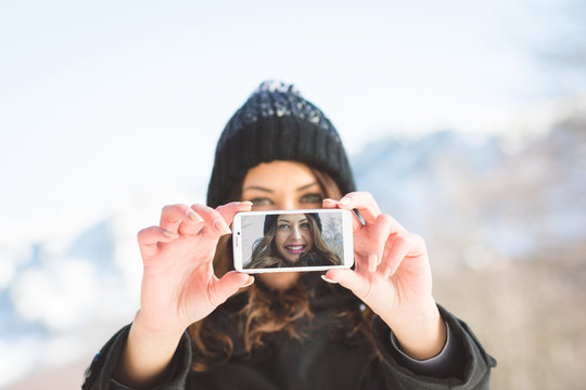 Young woman taking a selfie outdoors in winter