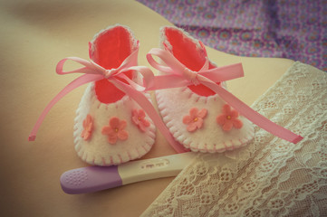 Newborn baby girl booties and pregnancy test